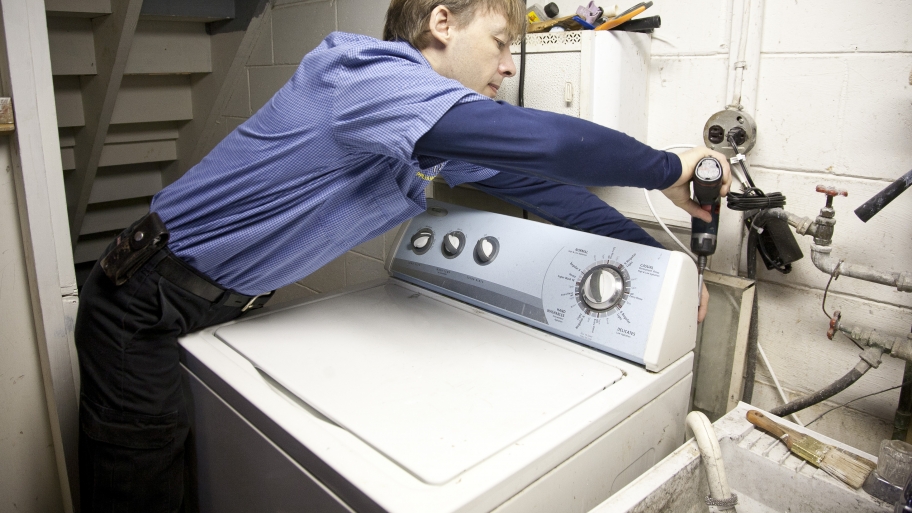 appliance repairman fixing a washing machine